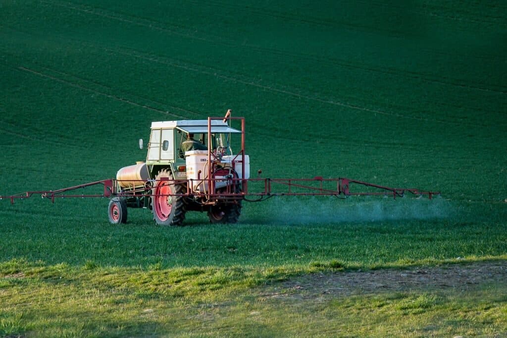 Tractor is pesticiding the field